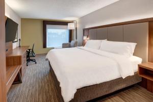 a hotel room with a large bed and a flat screen tv at Holiday Inn Express & Suites West Long Branch - Eatontown, an IHG Hotel in West Long Branch