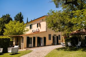 an external view of a house with chairs in the yard at CASENUOVE II - Casale con parco e piscina in Castiglioncello