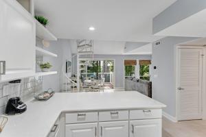 a kitchen with white cabinets and a dining room at Sea Colony---1805 Doubles Court in Bethany Beach