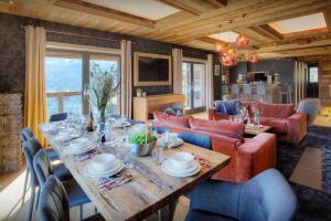 a dining room with a table and a couch at Chalet Kalyssia - OVO Network in Saint-Jorioz