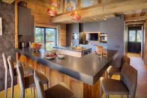 a kitchen with a large island in the middle at Chalet Kalyssia - OVO Network in Saint-Jorioz