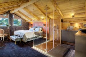 Schlafzimmer mit einem Bett und einer Glasdusche in der Unterkunft Chalet Kalyssia - OVO Network in Saint-Jorioz