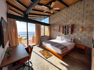 een slaapkamer met een bed, een bureau en een raam bij DIEM Vichayito Beachfront Eco-Luxury in Vichayito