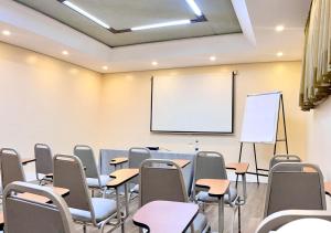 a classroom with a table and chairs and a whiteboard at Hotel Adrianópolis All Suites in Manaus