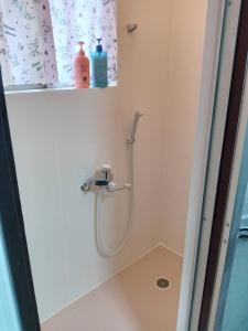 um chuveiro com uma mangueira na casa de banho em Marunishi em Osaka