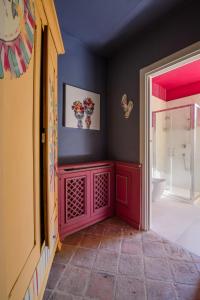 Segnavento -Rooms and Suites- في Manta: حمام مع خزانة حمراء في الغرفة