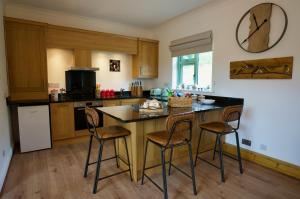 Tring Grange Cottage في Wigginton: مطبخ مع طاولة وكراسي في مطبخ