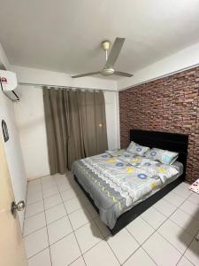 een slaapkamer met een bed en een bakstenen muur bij AB HOMESTAY PUTERI BAHANG APARTMENT in Kota Kinabalu