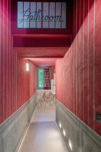 un corridoio con pareti rosse e un cartello che dice Babylon di Segnavento -Rooms and Suites- a Manta