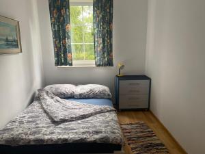a small bedroom with a bed and a window at Barwy Lata in Rowy