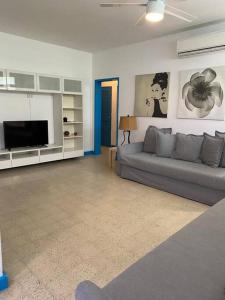 a living room with a couch and a television at #5 Walk To The Beach - 3br3br - 1113 Piccioni P5 in San Juan