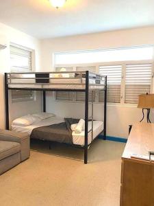 a room with two bunk beds and a couch at #5 Walk To The Beach - 3br3br - 1113 Piccioni P5 in San Juan