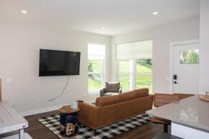 a living room with a couch and a flat screen tv at Brand new townhome in Downtown Naperville Family and Commute-friendly The May 3.5 in Naperville
