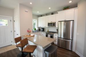 cocina con armarios blancos y nevera de acero inoxidable en Brand new townhome in Downtown Naperville Family and Commute-friendly The May 3.5, en Naperville