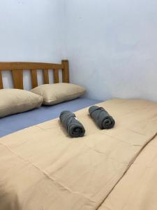 twee kussens op twee bedden in een slaapkamer bij RUMAHREHAT in Kampong Molek