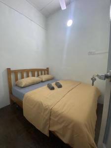 een slaapkamer met een bed met twee schoenen erop bij RUMAHREHAT in Kampong Molek