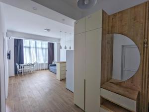 a kitchen and living room with a large wooden door at Brand new apartment in Kutaisi in Kutaisi