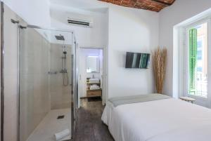 a white bedroom with a bed and a shower at Puerta del Sol Apartamento economico in Madrid