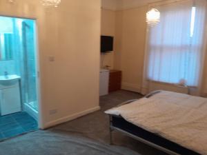 a bedroom with a bed and a window and a television at Falcon Villa in Grimsby