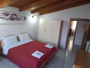 1 dormitorio con 1 cama grande con manta roja en B&B da Marianna en Samughèo