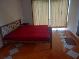 - une chambre avec un lit doté d'un drap rouge dans l'établissement The Orange Home, à Kotagiri