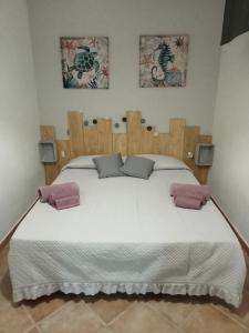 a bedroom with a large white bed with two pillows at Casa Vacanze Il Mirto Bianco in Olmedo