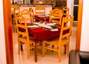 a dining room table and chairs with a red table cloth at Randa Cottages Moshi in Kirua