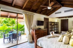 ein Schlafzimmer mit einem Bett und eine Terrasse mit einem Tisch in der Unterkunft Sunny Vacation Villa No 88 in San Rafael del Yuma