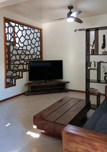 a living room with a flat screen tv and a coffee table at BEL HORIZON Nosy Be in Nosy Be