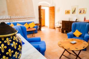 a living room with blue chairs and a table at CASENUOVE II - Casale con parco e piscina in Castiglioncello