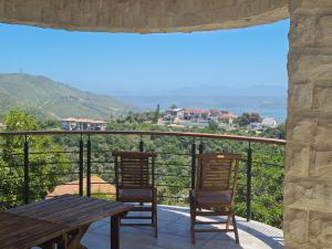 a patio with two chairs and a table on a balcony at Castle On The Heads in Knysna