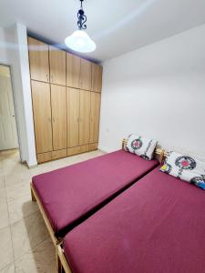 1 dormitorio con 1 cama grande con sábanas moradas en אצל אתי, en Safed