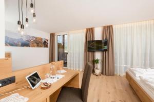 Zimmer mit einem Schreibtisch aus Holz und einem Bett in der Unterkunft Hotel Royal und Ferienhaus Annabel in Sexten