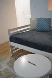 een kamer met een bed en een witte salontafel bij Nice apartament with small tub in Warschau