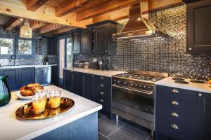 a kitchen with blue cabinets and a table with glasses of orange juice at Chalet Ruisselet - OVO Network in Châtel
