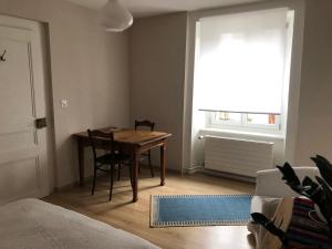 a dining room with a table and a window at Joli studio renové avec goût proche de la gare in Le Locle