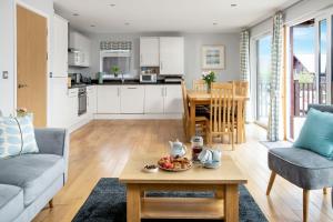 a kitchen and living room with a table and chairs at Sunbow at Retallack Resort in Saint Columb Major