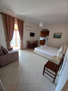 a bedroom with a bed and a couch and a table at GKOROS HOUSE OLD TOWN in Himare