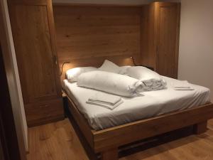 uma cama com lençóis brancos e almofadas em Soul Mountain Lodge em Mühlbach am Hochkönig