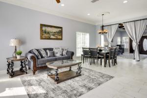 uma sala de estar com um sofá e uma mesa em Luxe Southwest Houston Home with Balconies and Patio! em Houston