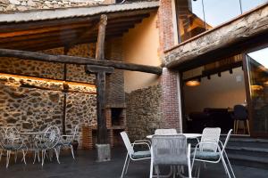 un grupo de sillas y mesas en un patio en La Casa del Guarda - Turismo Sotosalbos, en Sotosalbos