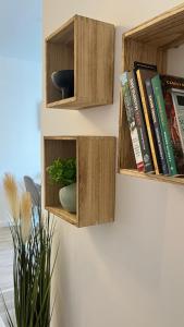 a shelf with wooden boxes on a wall with books at The Nest in Floreşti