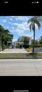 a street with a building and a palm tree at Confortable y lujoso apartamento en santiago in Santiago de los Caballeros