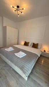 a bedroom with a large bed with two towels on it at The Nest in Floreşti