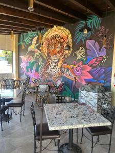 ein Wandbild an der Wand eines Restaurants mit Tischen und Stühlen in der Unterkunft SOLSTICIO 212 in Cholula de Rivadavia