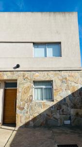 - un bâtiment en pierre avec deux fenêtres et une porte dans l'établissement Bragado Siempre 247, à Bragado