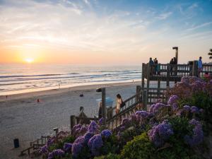 a group of people on the beach at sunset at Pacific Terrace Hotel in San Diego