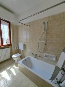 a bathroom with a bath tub and a toilet at Valle Intelvi Panorama in Castiglione dʼIntelvi