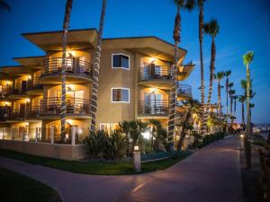 a large building with palm trees in front of it at Pacific Terrace Hotel in San Diego