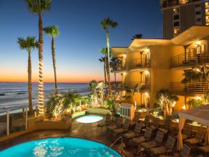 a resort with a swimming pool and the ocean at Pacific Terrace Hotel in San Diego
